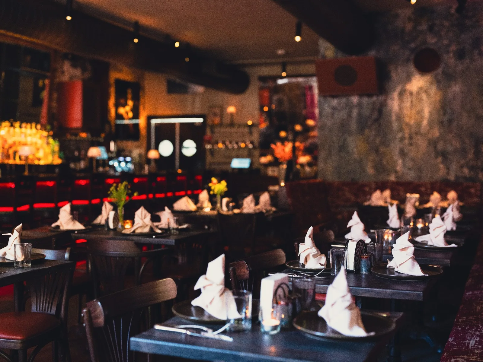 Bar seating at GUSI's first-floor tavern — candlelight and warm pendant lighting at 432 Sixth Avenue, NYC